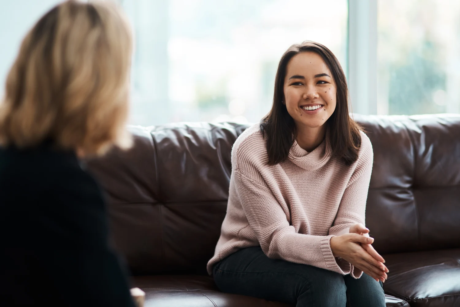 A woman smiles during a face-to-face conversation with a counselor.